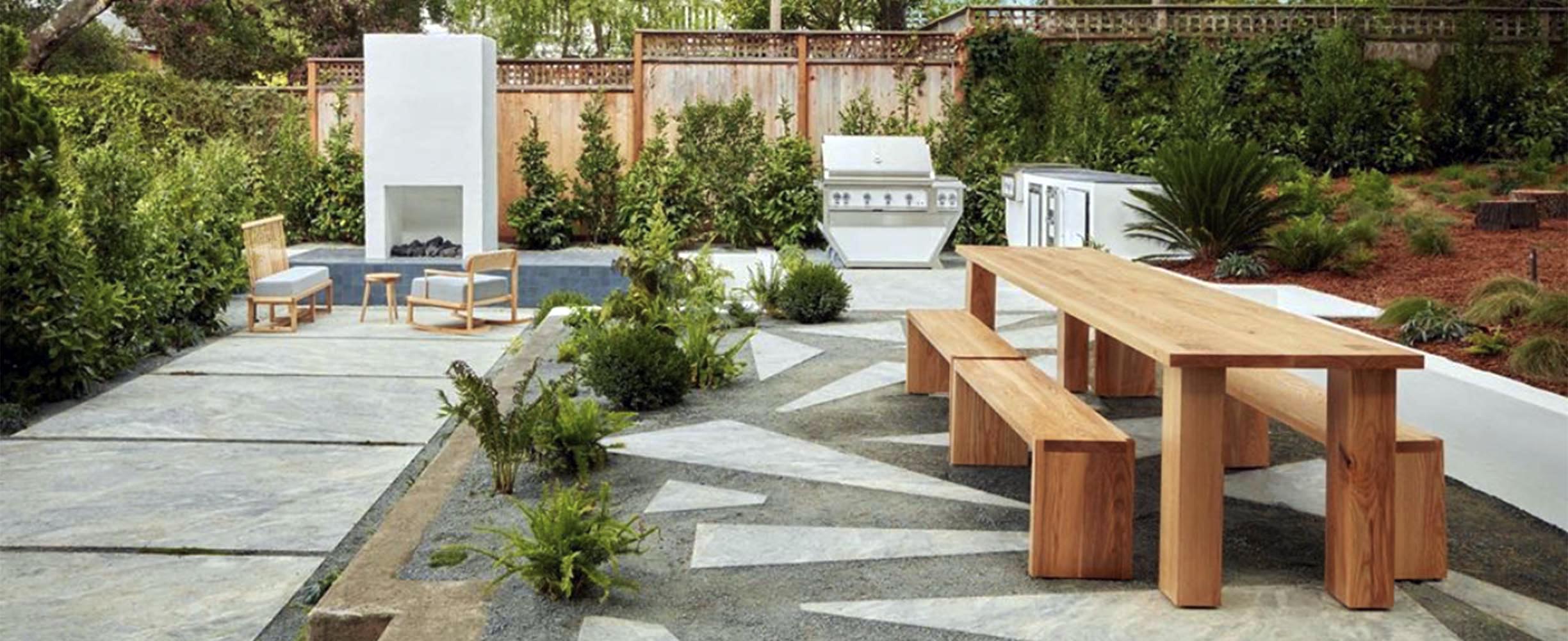 Modern patio design with concrete walk ways, hardwood wooden table and benches, firepit and barbeque in a San Franciso neighborhood